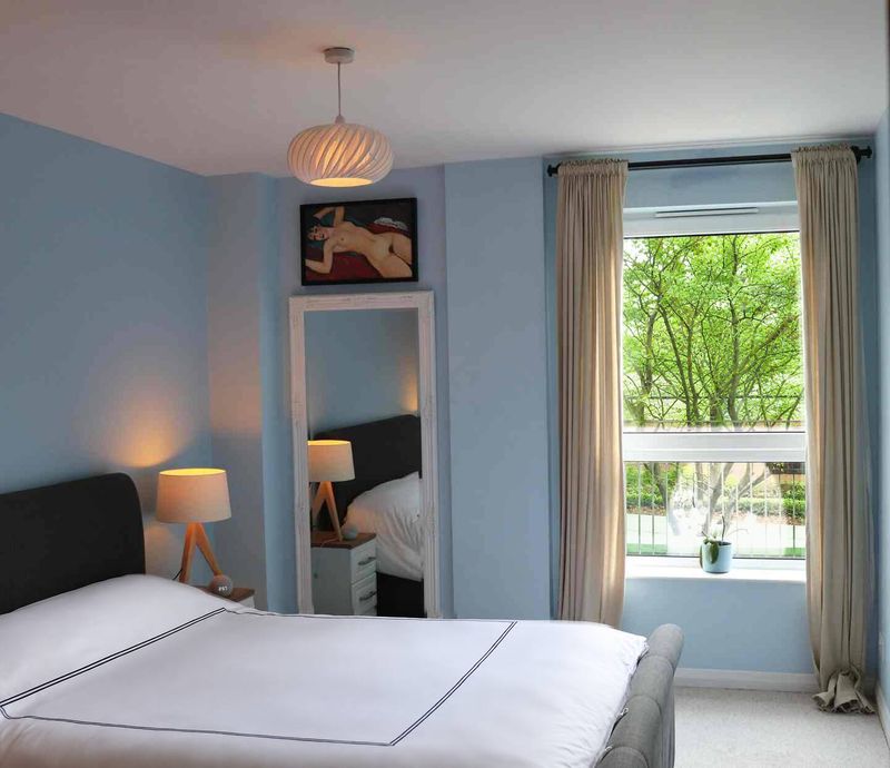 The second bedroom, calm in blue-grey with a king-size bed